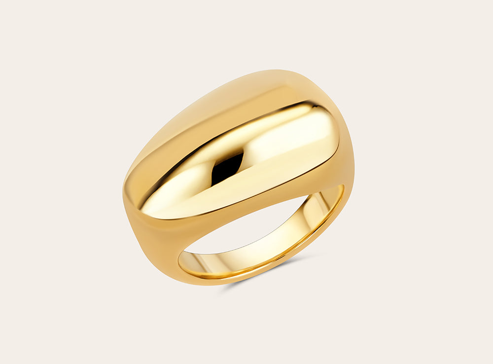 Product photo of the golden signature ring on a flat white background. 