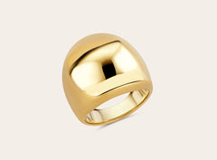 Product photo of the golden statement ring on a light background. Perspective from above. 