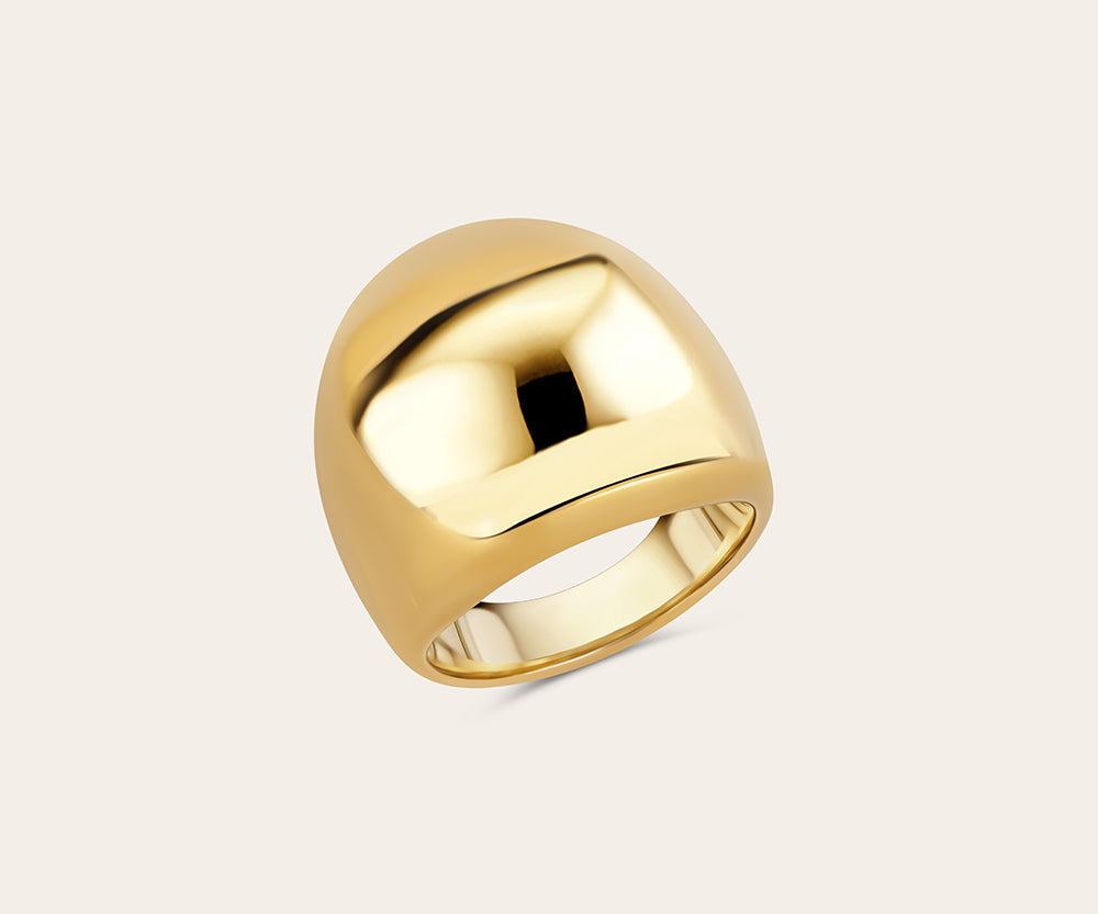 Product photo of the golden statement ring on a light background. Perspective from above. 