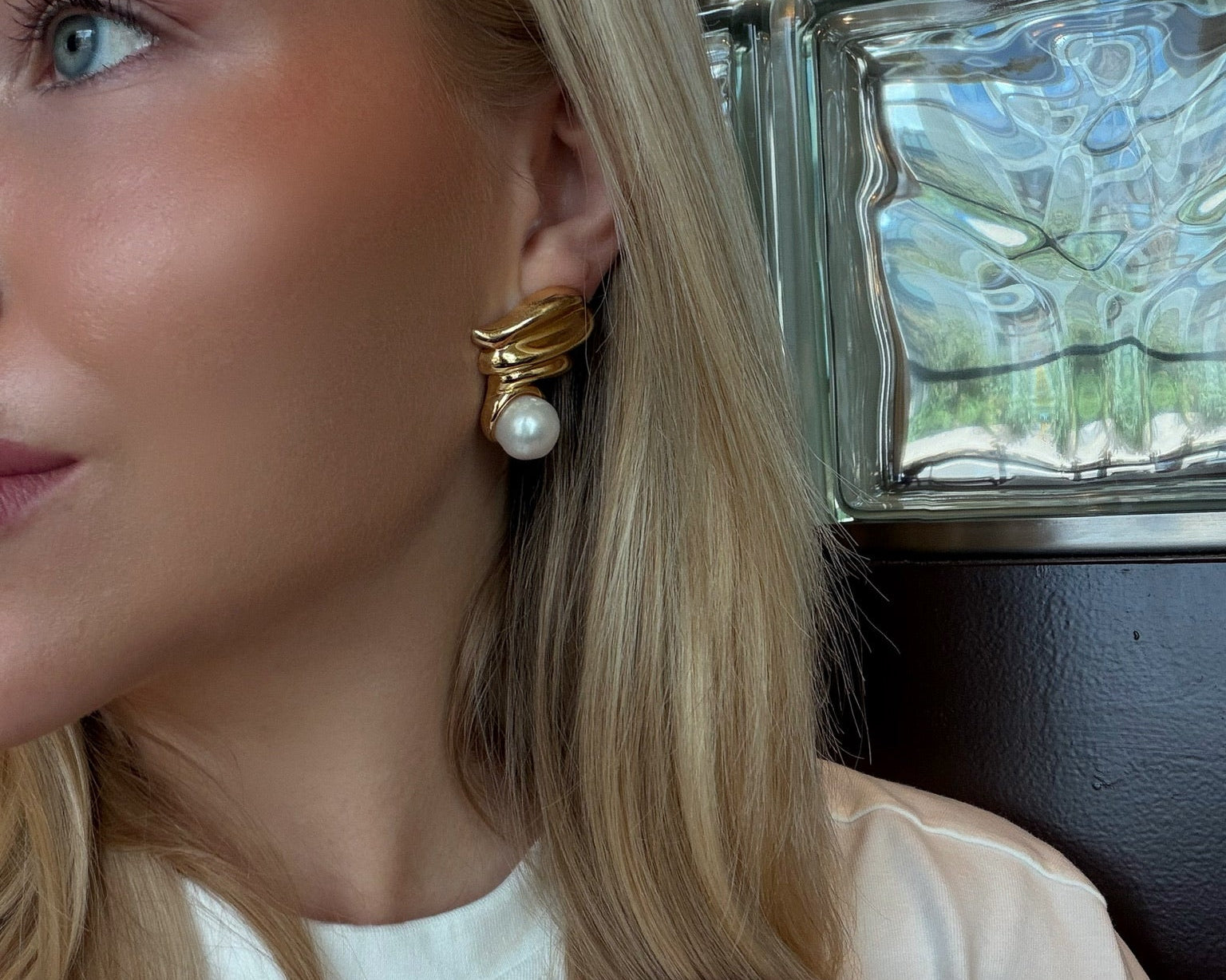Model wearing gold plated earrings with white pearls