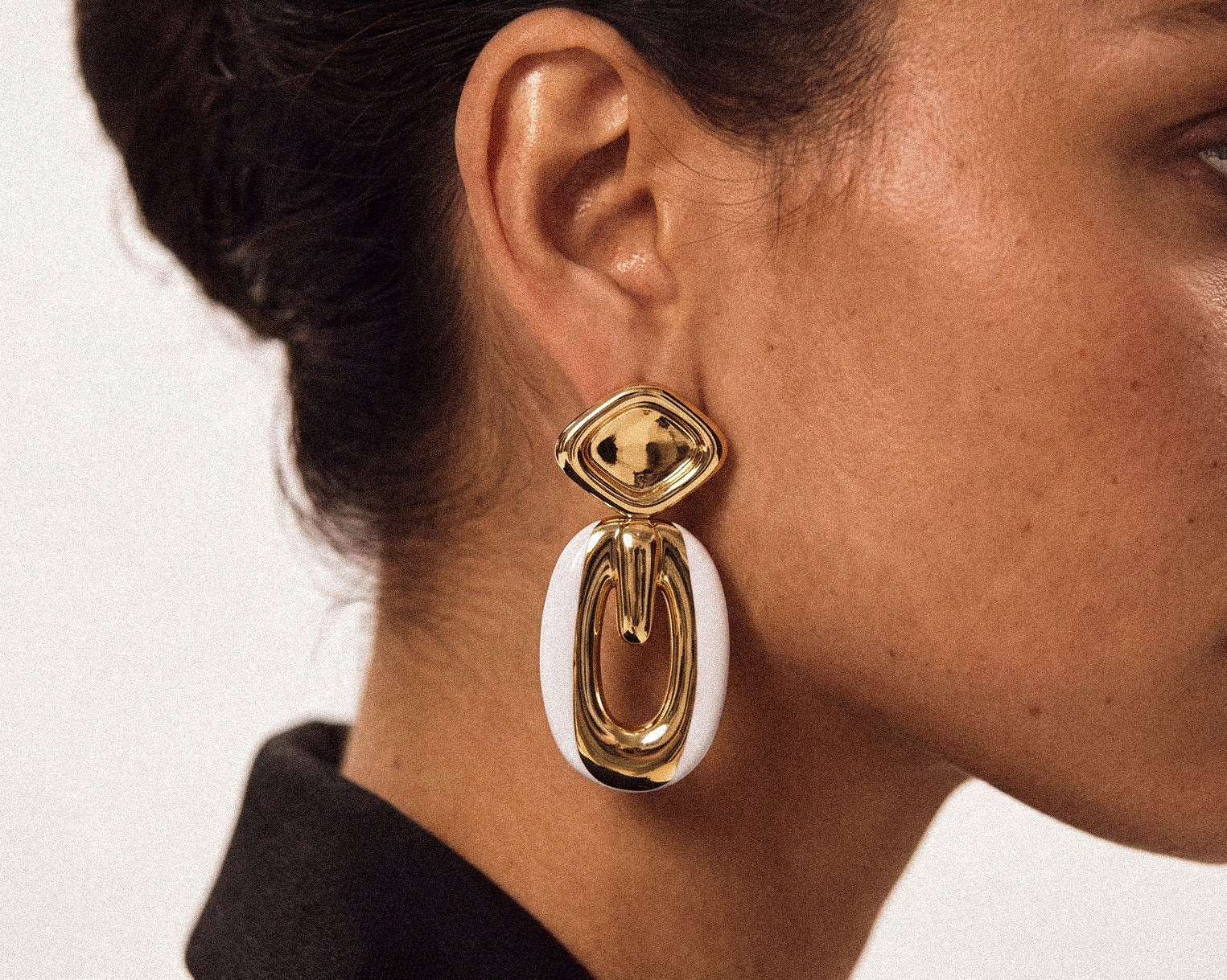 Model wearing gold plated drop earrings