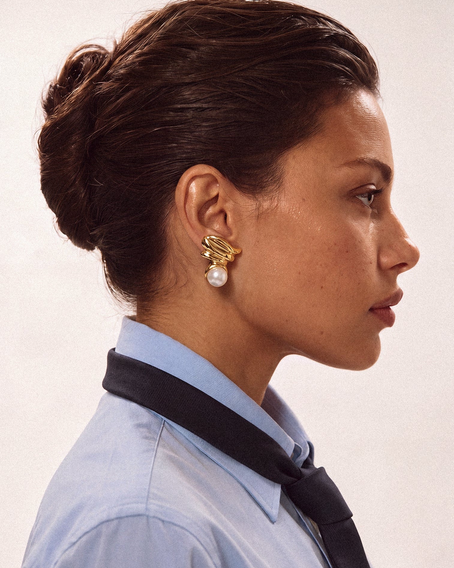 Model wearing gold plated pearl earrings
