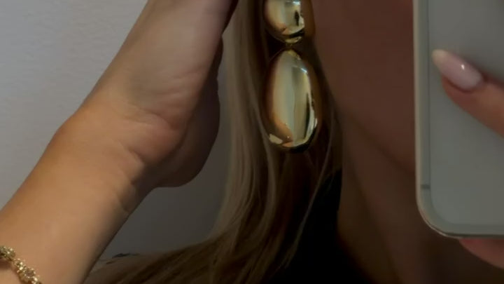 Close-up of gold plated oval earrings