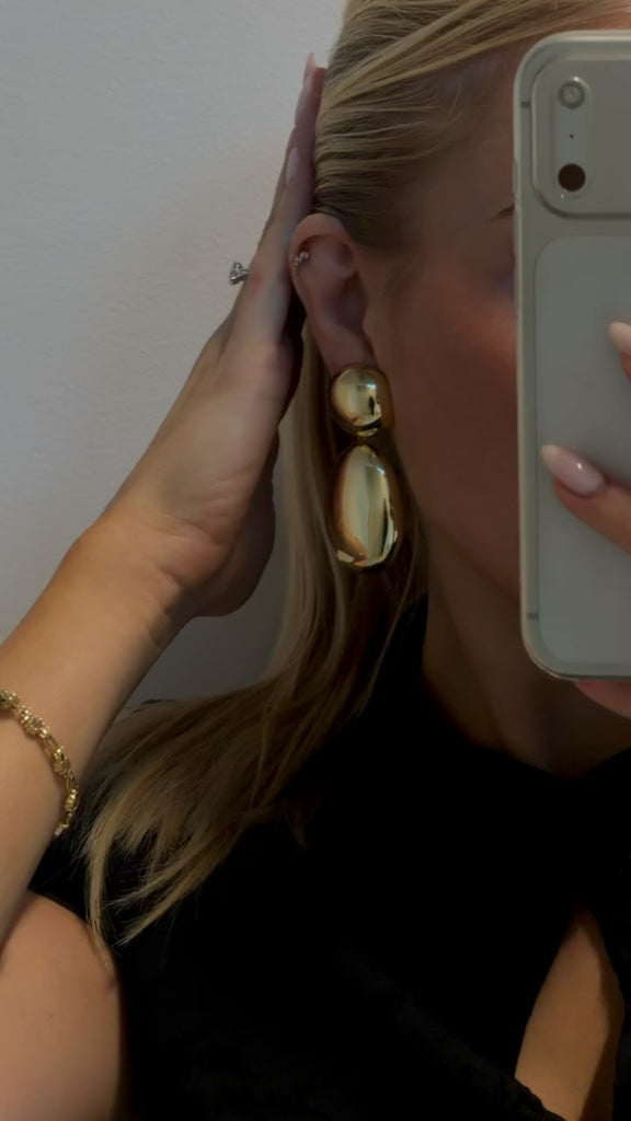 Close-up of gold plated oval earrings